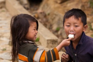 Children sharing ice-cream on stick near Sapa.