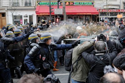 Policemen fight with activists during a protest ahead of the 2015 Paris Climate Conference at the place de la Republique, in Paris, Sunday, Nov. 29, 2015. More than 140 world leaders are gathering around Paris for high-stakes climate talks that start Monday, and activists are holding marches and protests around the world to urge them to reach a strong agreement to slow global warming. (AP Photo/Laurent Cipriani)