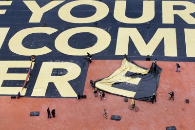 Une affiche qui mesure 8000m2 et pese sept tonne a ete posee, ce samedi 14 mai 2016, sur la Plaine de Plainpalais a Geneve par une centaine de benevoles. La plus grande question du monde y est posee: WHAT WOULD YOU DO IF YOUR INCOME WERE TAKEN CARE OF? concernant la mise en place d un revenu de base inconditionnel qui sera l objet des prochaines votations du 5 juin prochain. Cette affiche bat le record actuel du livre Guinness des records pour la plus grande affiche du monde. (KEYSTONE/Magali Girardin)