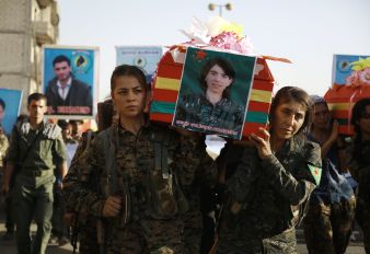 Syrian-Kurdish women carry the coffin of a female fighter in Syria's northeastern city of Qamishli on July 21, 2016 during the funeral of sixteen fighters killed battling the Islamic State (IS) group in Manbij. Thousands of IS soldiers were reported killed in the Manbij battles along with about 150 SDF volunteers, including six from the International Brigade.(William Savage, from the US was killed rescuing civilians). 