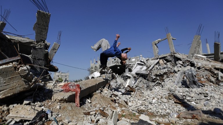 A Palestinian boy practices parkour in the ruins of occupied and blockaded Gaza